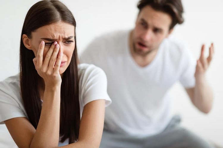 Family Quarrel. Aggressive Husband Shouting At Unhappy Crying Wife Sitting In Bedroom At Home. Conflicts In Marriage. Domestic Abuse And Violence. Problems In Relationship. Selective Focus. Emotional manipulation in marriage.