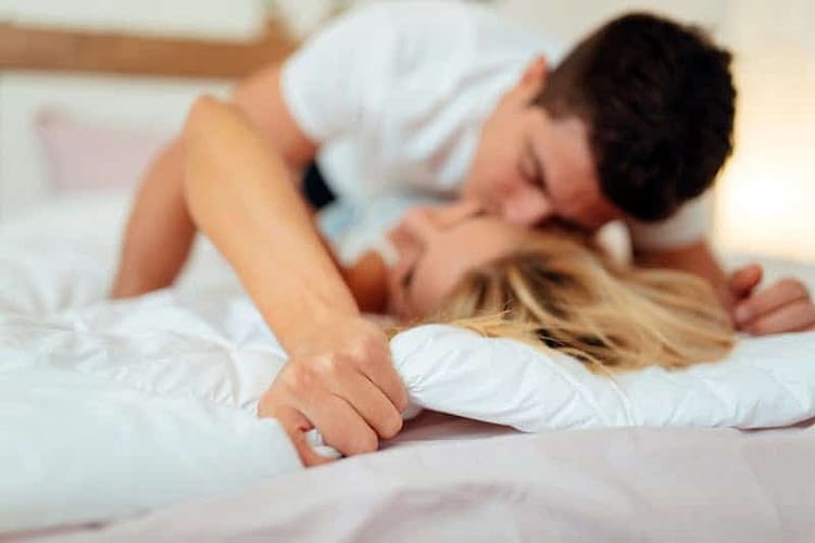 Happy couple in bedroom enjoying sensual foreplay